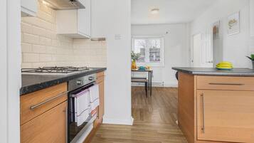 Una cocina moderna con estufa a gas, horno y armarios de madera.