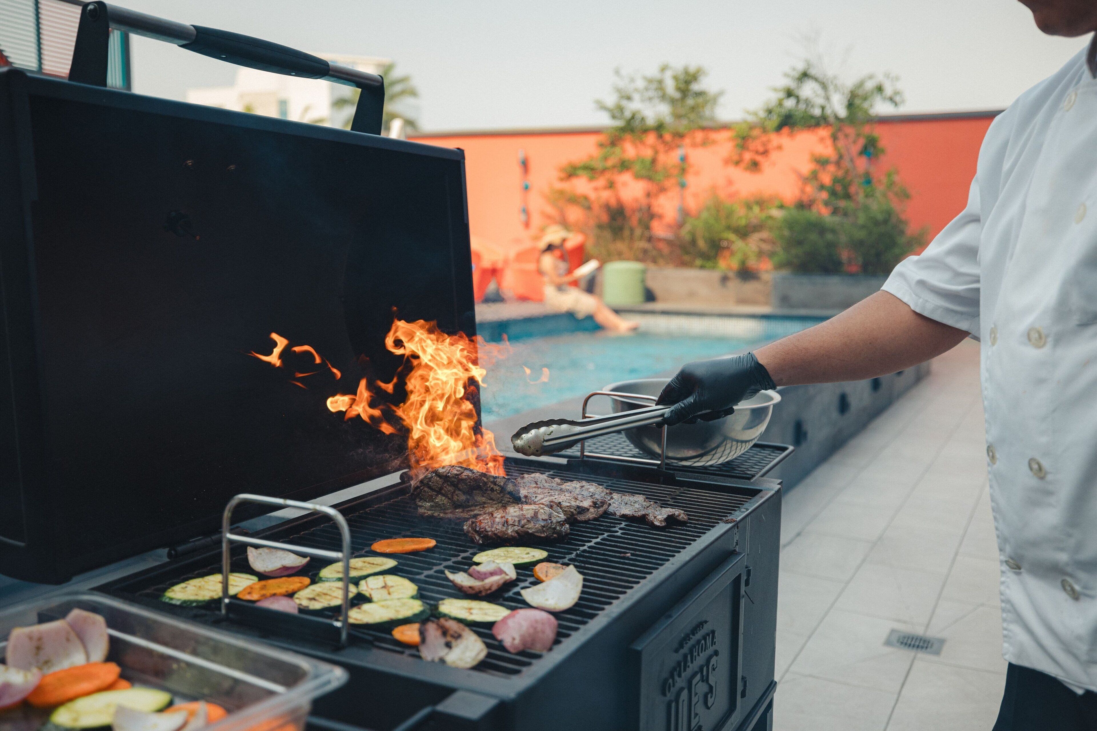 Ein Grill mit verschiedenen Fleischsorten und Gemüse, das zubereitet wird.