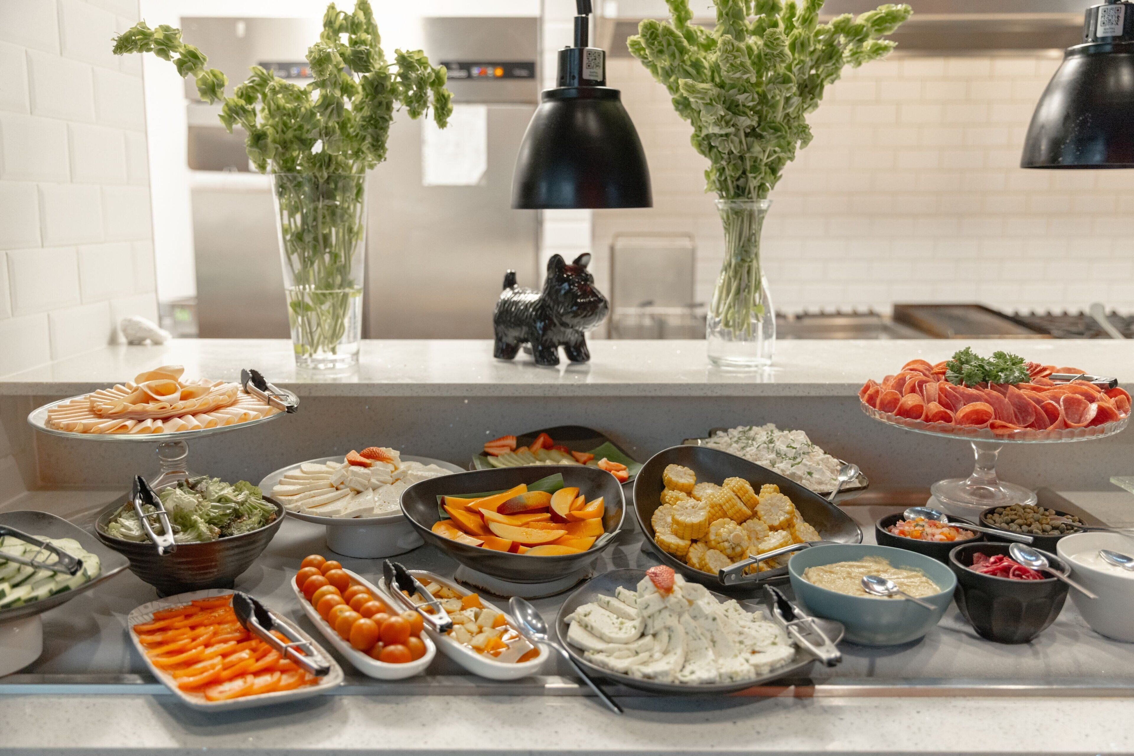 A buffet with various food items and a decorative dog figurine on the counter.