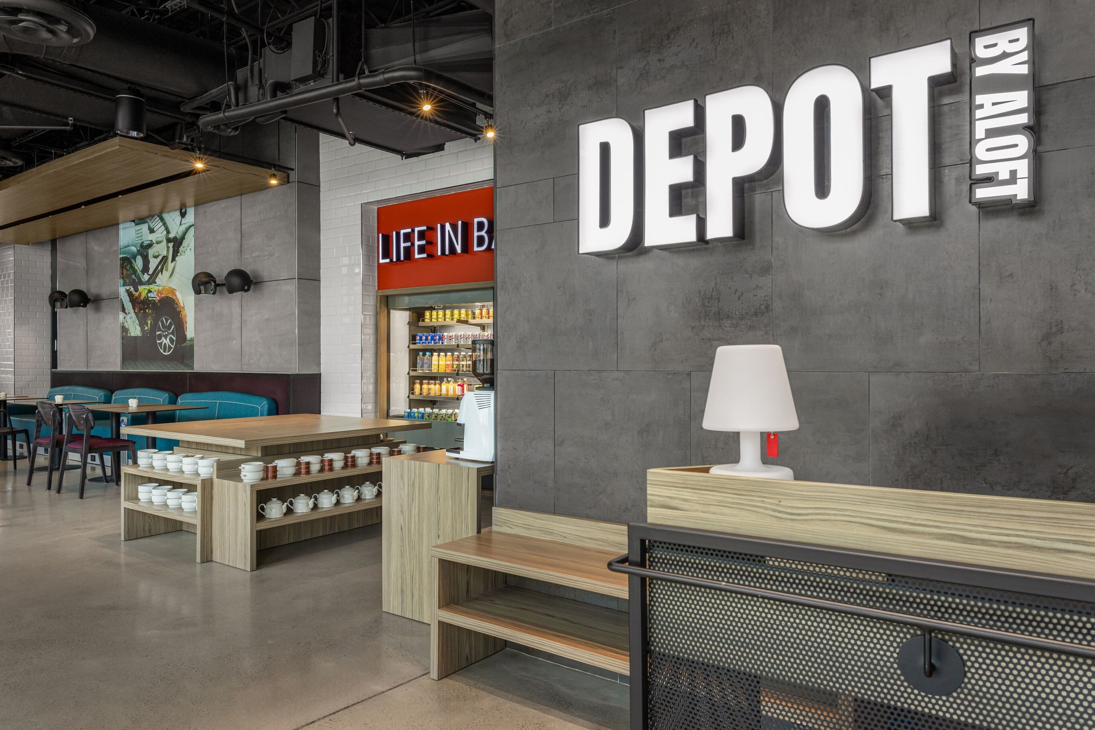 A modern interior with a 'DEPOT BY ALOFT' sign, seating areas, and a visible store with a 'LIFE IN B' sign.