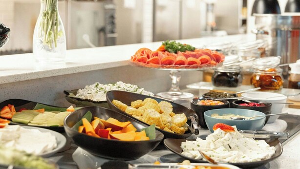 A buffet with various food items and a 'CHARGED' sign above. - Aloft by Marriott San Pedro Sula (San Pedro Sula)