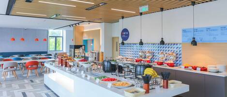 A modern breakfast buffet with various food options, a seating area with chairs, and a clean, well-lit interior.