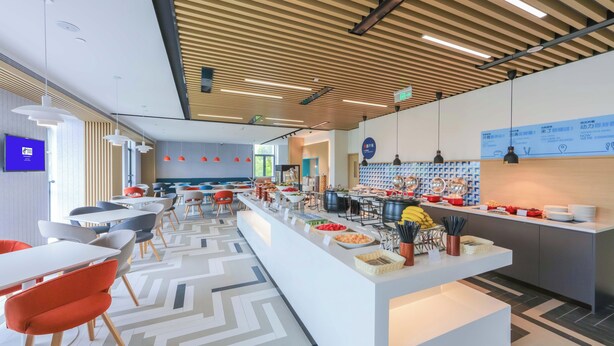 A modern cafeteria with a long counter, various food items, and seating arrangements. - Holiday Inn Express Shanghai Pudong Airport by IHG (Shanghai)