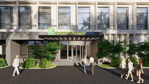 A Holiday Inn Express building with a modern facade, large windows, and a covered entrance area. - Holiday Inn Express Shanghai Pudong Airport by IHG (Shanghai)