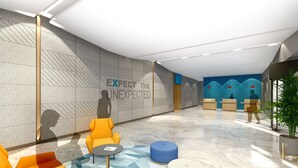 A modern lobby with a textured wall, a reception desk, seating areas, and a large plant. - Holiday Inn Express Shanghai Pudong Airport by IHG (Shanghai)