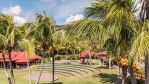 Un resort con palmeras, una piscina y un edificio de techos rojos.