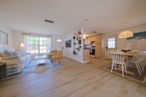 Relax in this open living area with a sofa, coffee table, and dining space.