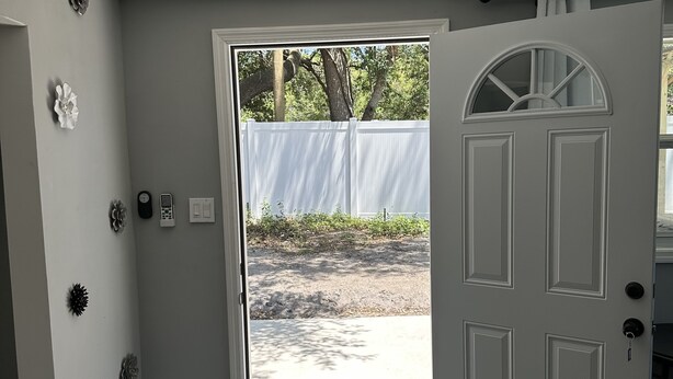 Una habitación con una puerta blanca, un ventanal pequeño y un timbre.