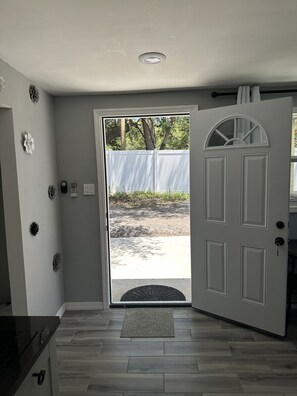 A room with a white door, a small window, and a doorbell. - Home away from home (Clearwater)