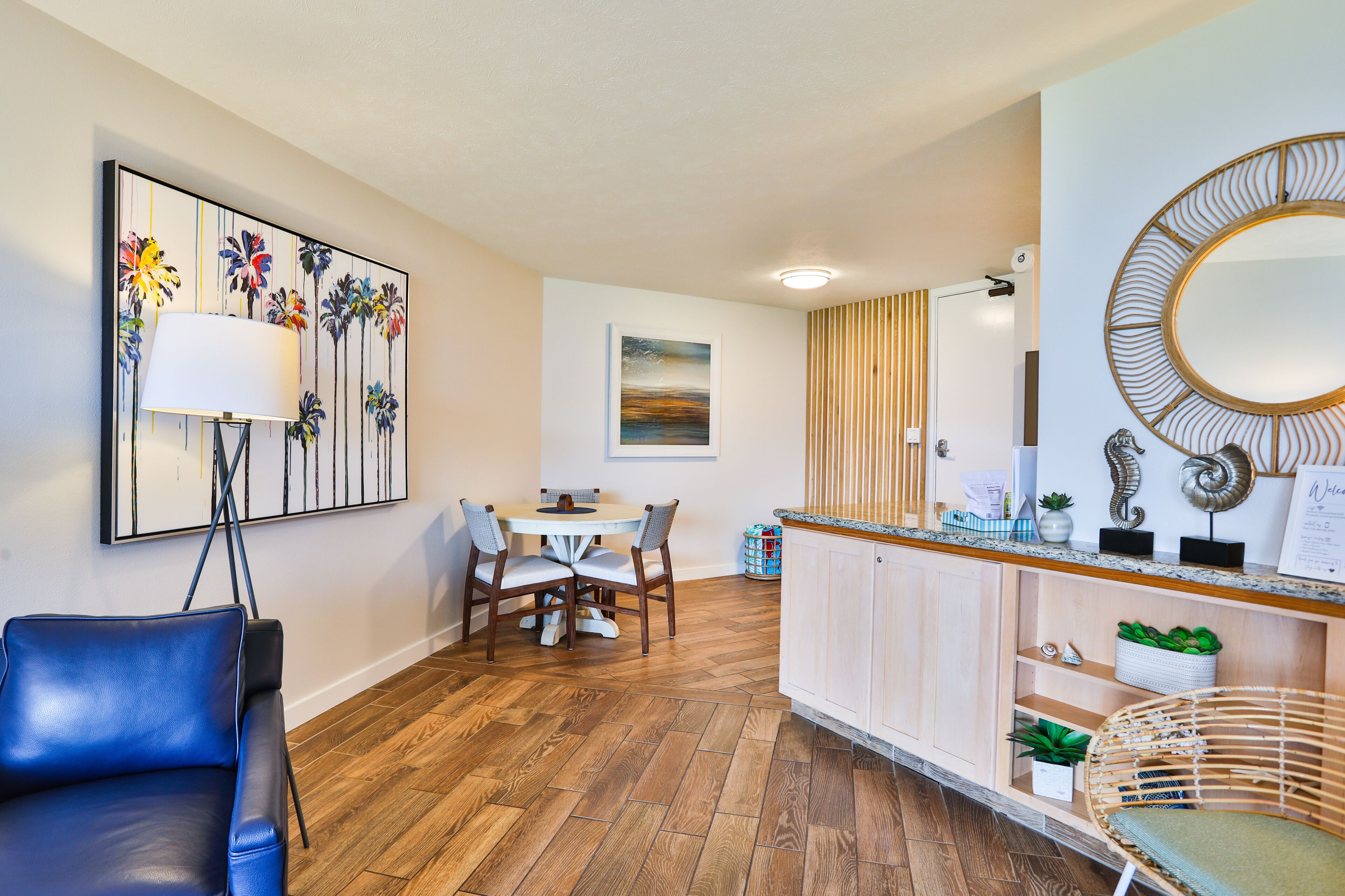 Een moderne keuken met houten vloeren, een eethoek met een tafel en stoelen, en een keukentrap met een spoelbak en decoratieve objecten.
