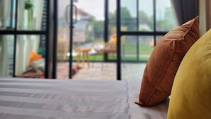 A room with a bed, pillows, and a large window with a view of the outside. - Capital O 75422 Million Pillows  (Chiang Mai)