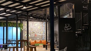 A modern interior with a map wall, seating area, and a staircase. - Capital O 75422 Million Pillows  (Chiang Mai)
