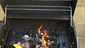 En kolgrill med glödande kol och lågor.