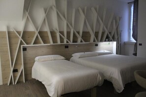 A hotel room with two beds, wooden headboard, and a modern design. - affittacamere i due cavalieri (Turin)