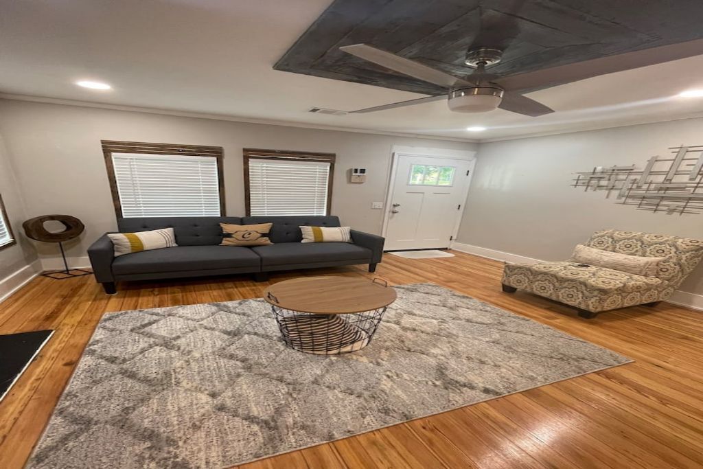 A living room with a grey sofa, patterned armchair, and a round coffee table.
