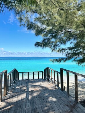 A wooden deck leading to a beach with turquoise water and clear skies. - Your favorite getaway place (Bimini)