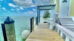 A wooden pier leading to a building with a covered area and a door, overlooking a calm sea. - Your favorite getaway place (Bimini)
