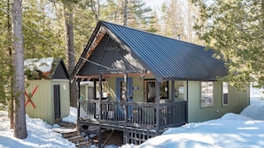 A cabin with a porch, surrounded by snow and trees. - Sugarloaf camp - ski/ outdoors rustic retreat (Carrabassett valley)