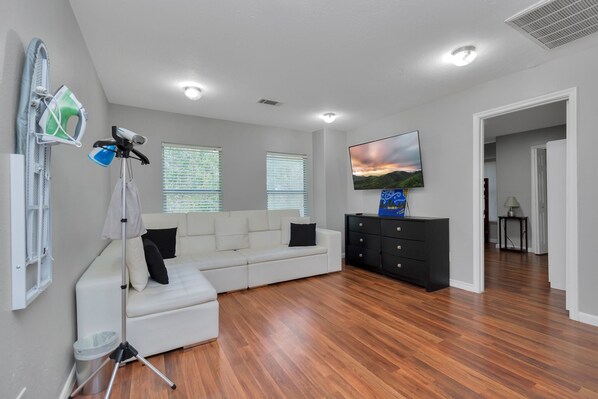 Relax in this stylish living room with a sofa, flat-screen TV, and floor lamp.