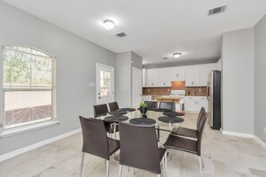 Enjoy meals at the round dining table surrounded by comfortable chairs.
