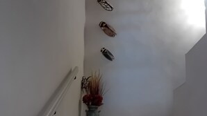 Un escalier orné d’un vase en métal et d’un objet décoratif fixé au mur.
