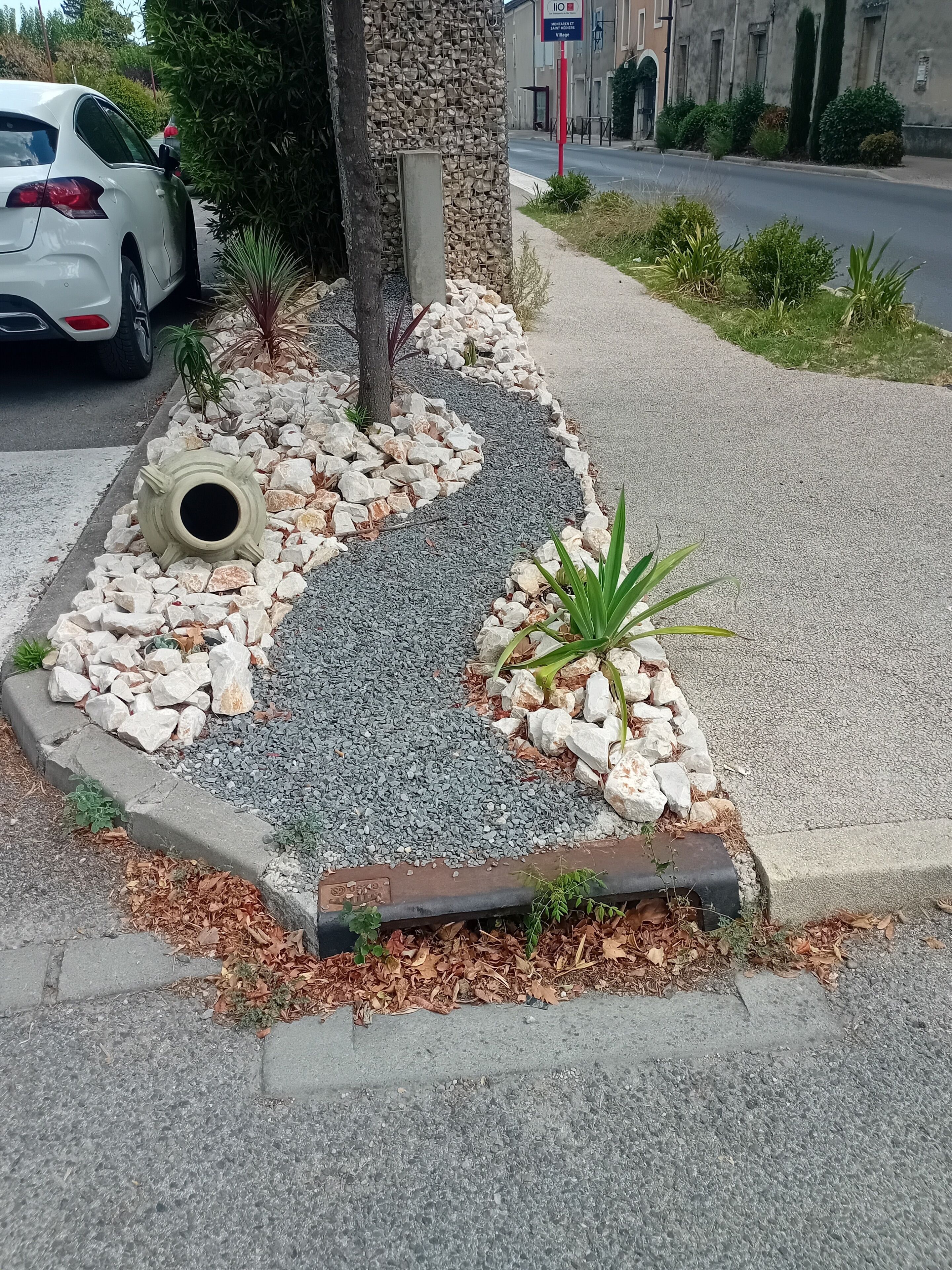 A landscaped garden area with a gravel path, rocks, and plants.