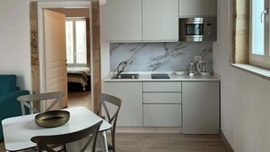 A compact kitchen with a marble backsplash, a built-in microwave, and a sink. - RUA 39 fine apartments 5 (Syracuse)
