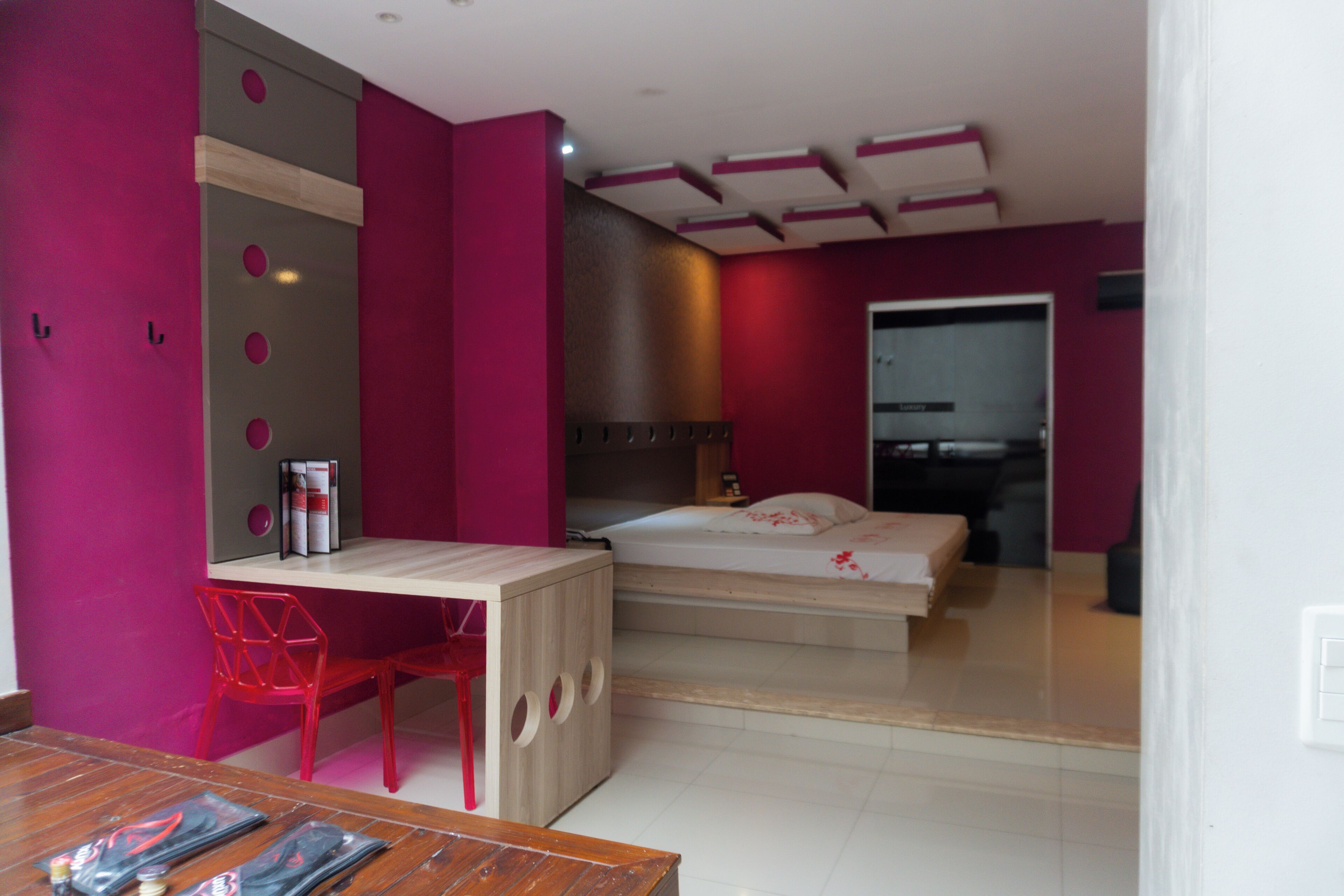 A bedroom with a bed, a desk, and a chair.