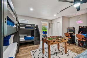Una habitació amb llits superposats, taula de futbolí i jocs recreatius.