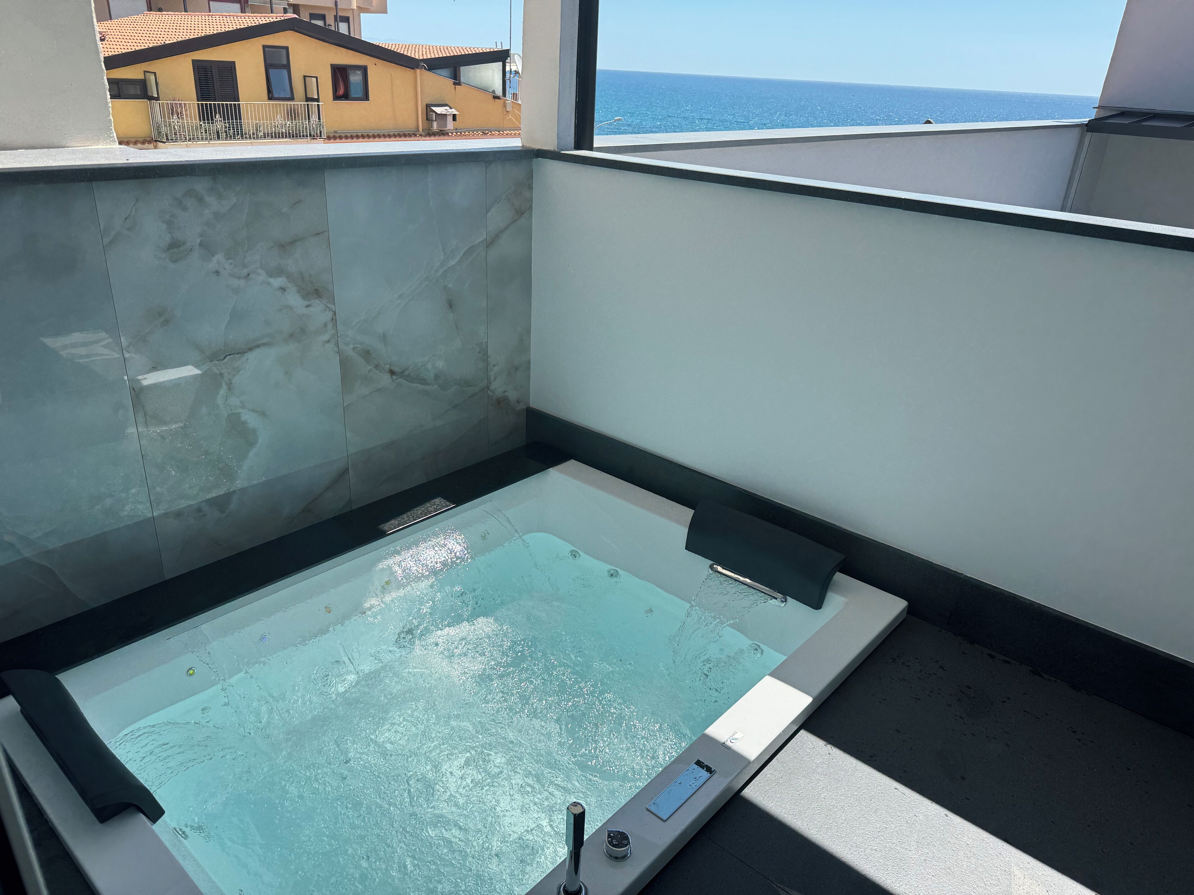 Una piscina interna moderna con una vista aperta sull'oceano attraverso una grande finestra.