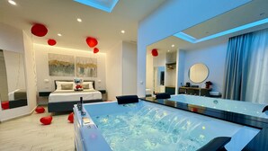 Une salle de bain moderne avec une grande baignoire, un miroir et un lit décoré d’un motif en forme de cœur.