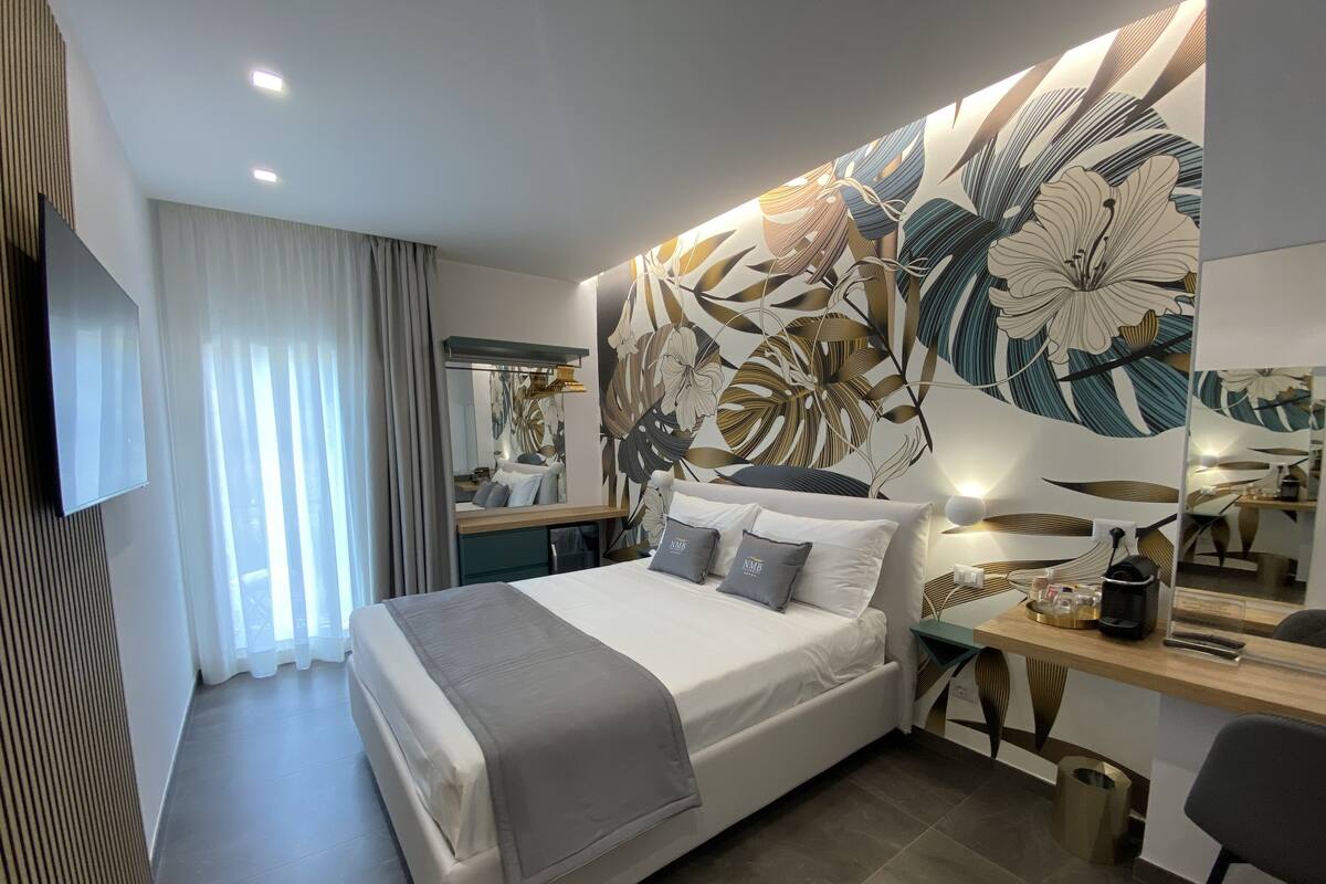 Une chambre d’hôtel moderne avec un grand lit, un bureau et un miroir.