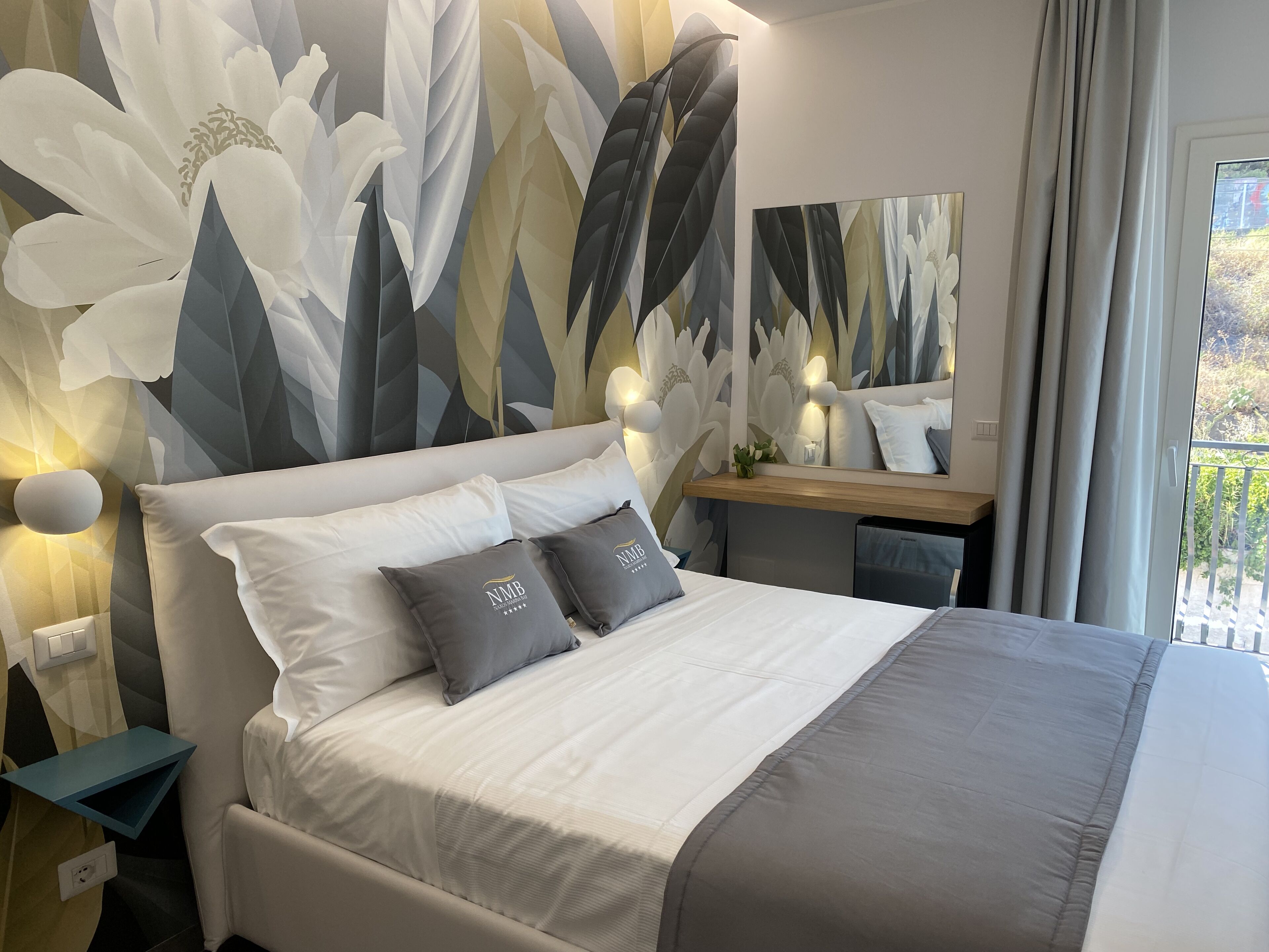 Ein modernes Hotelzimmer mit einem großen Bett, einem Schreibtisch und Blick auf Grünflächen.