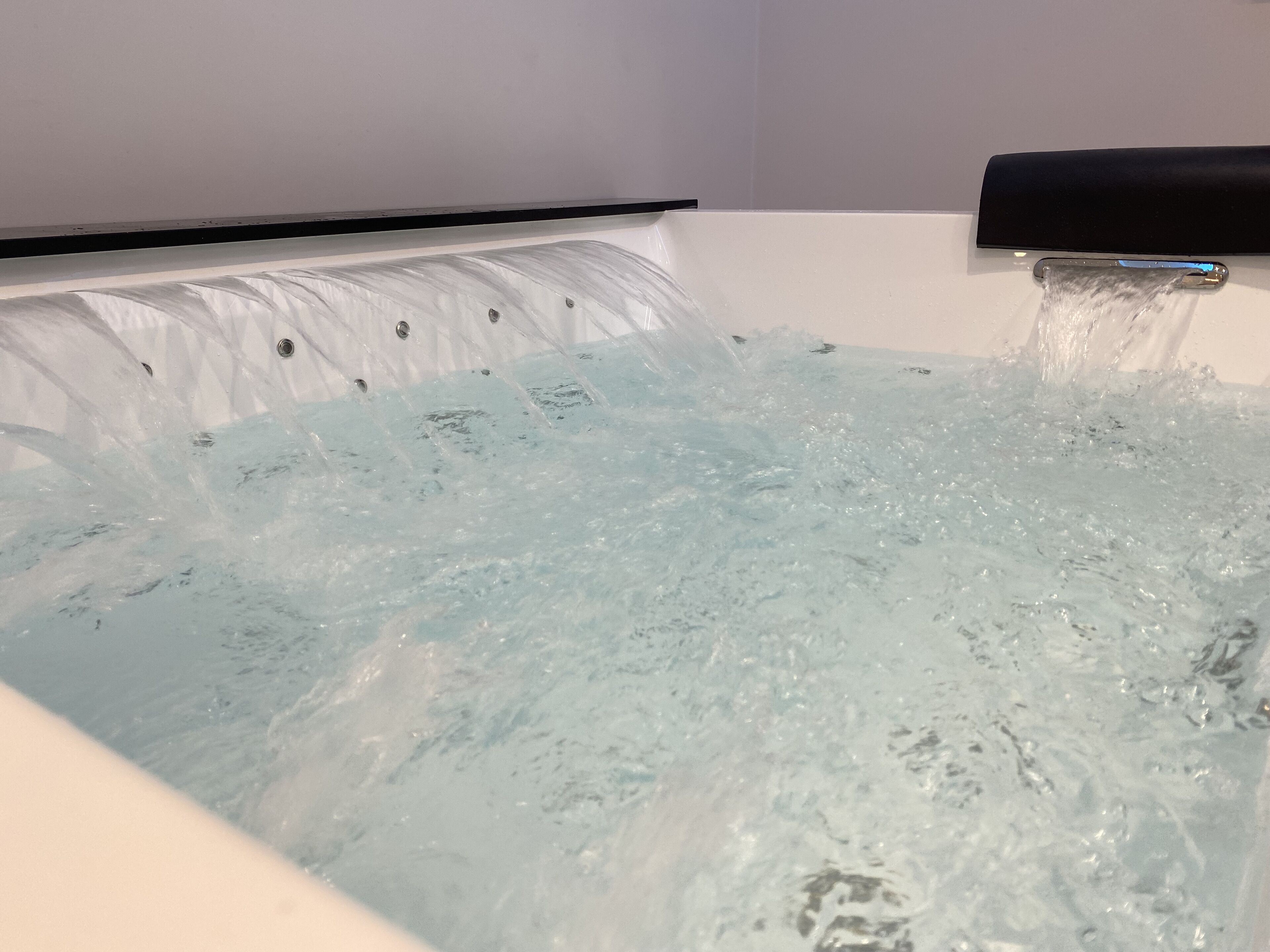 A bathtub with water flowing from a faucet.