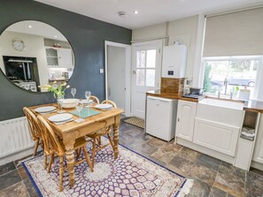 Una cocina moderna con una mesa de comedor de madera, armarios blancos y un horno empotrado.