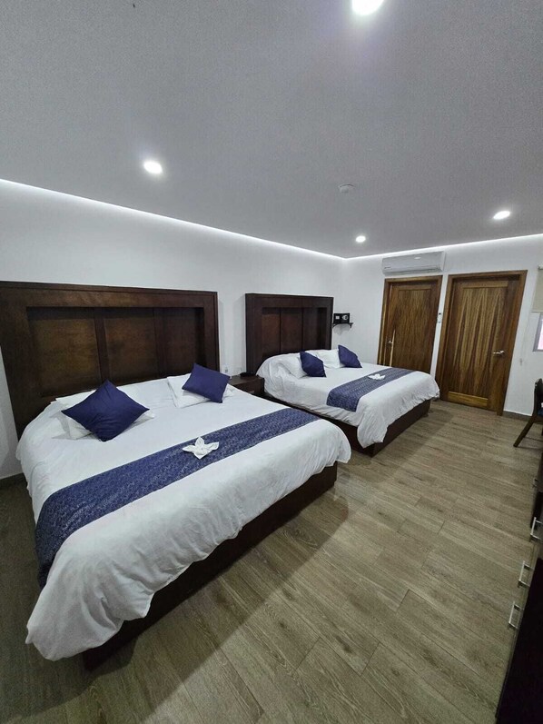 Habitación triple familiar, varias camas, vista a la ciudad | Camas Select Comfort, caja de seguridad en la habitación y escritorio 