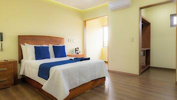 Un dormitorio con cama de madera, ropa de cama blanca y mesita de noche de madera.