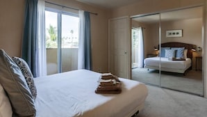 Ein Hotelzimmer mit Bett, Badezimmer mit Spiegel und Blick ins Freie.