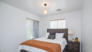 A bedroom with a bed, nightstand, lamp, and window blinds. - Stylish Vacation Home Phoenix - Low Rates NOW! (Phoenix)
