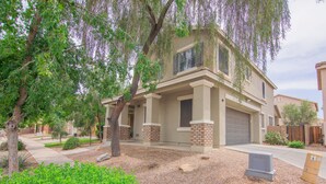 A two-story house with a garage, surrounded by trees and a well-maintained lawn. - Stylish Vacation Home Phoenix - Low Rates NOW! (Phoenix)