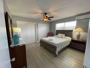 Cozy retreat with a single bed, ceiling fan, and large window for natural ventilation.