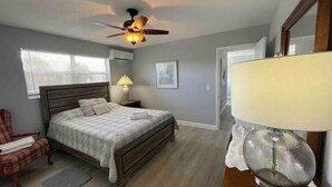 A bedroom with a bed, a chair, a lamp, and a ceiling fan. - NEW LISTING - 3 Min Walk-Beach, Hot Tub, Tennis, Wi-Fi (Riviera Beach)