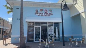 A storefront with a sign reading "SWEET TREATS & ICE CREAM" and a menu board outside. - Hot Tub, Walk to Beach, Snorkeling, Surfing (Riviera Beach)
