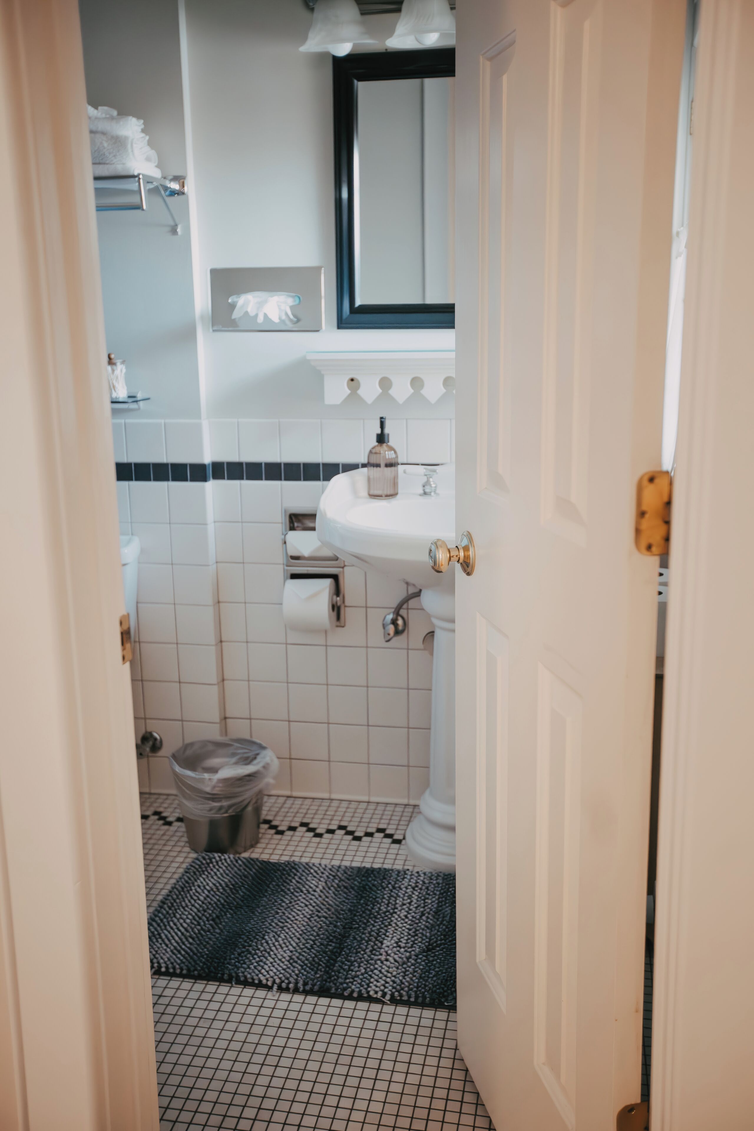 A bathroom with a white sink, a mirror, and a tiled floor.