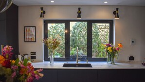 A kitchen with a large window, a sink, and two pendant lights. - 4 Bedroom House in Sotogrande Alto (San Roque)