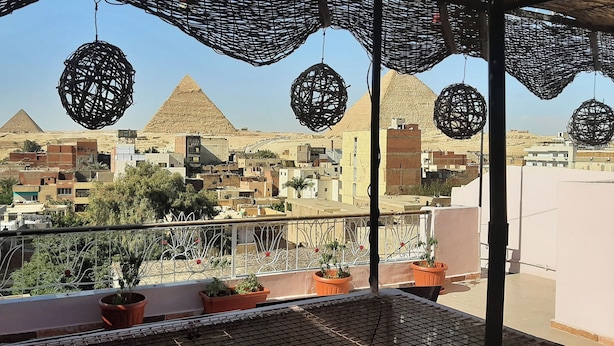 A balcony with wicker ceiling decorations, potted plants, and a view of the pyramids. - 9 SIDY GABAR ST NAZLET EL SMAN HARAM GIZA (Nazlet el sman-Haram)