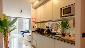 A modern kitchen with a microwave, sink, and countertop. - Charming Studio in Bolhão Market (Oporto)
