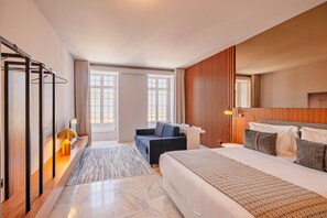 A hotel room with a bed, a desk, a chair, a TV, and a window. - Studio with View in Bolhão Market (Oporto)