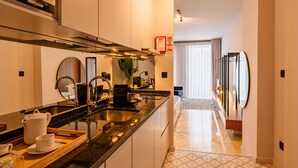 A modern kitchen with a central island, stainless steel appliances, and a view into the living area.