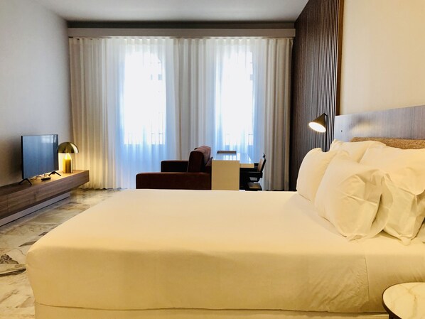 Relax in comfort with a large bed, flat-screen TV, and spacious workspace.